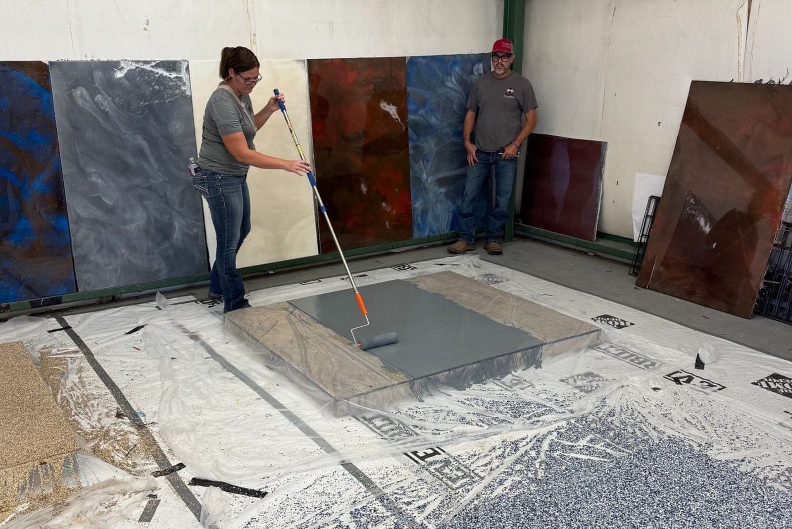 Training participant rolling a coating onto a sample panel in the Polymer Nation training bay