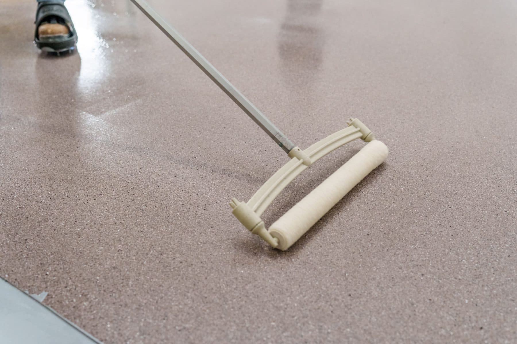Spiked roller backrolling a fresh Scapes aggregate floor